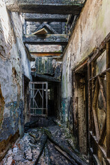 Corridor of burnt house, charred walls. Consequences of fire, war, etc.