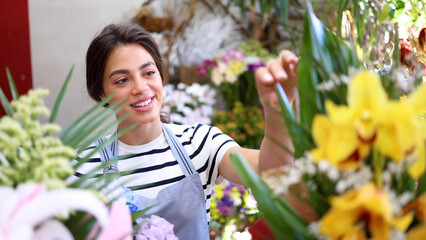 Fototapeta premium Young florist enjoying working at the flower shop