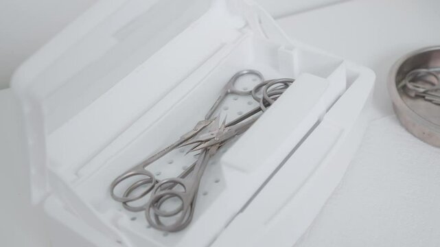 Manicurist preparing instruments for nail care procedures using professional medical equipment. Hardware sterilization of medical manicure tools using the dry heat method