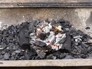 Burning of charcoal to roast meat concept.