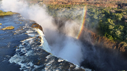 Water Fall Rainbow At Victoria Falls In Matabeleland North Zimbabwe. Giant Waterfalls. Nature Landscape. Victoria Falls At Matabeleland North Zimbabwe. Zambezi River. Travel Scenery.
