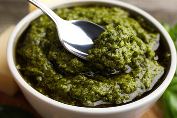 Taking tasty pesto sauce at table, closeup