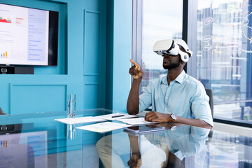 Using VR headset, businessman interacting with virtual interface in modern office, copy space