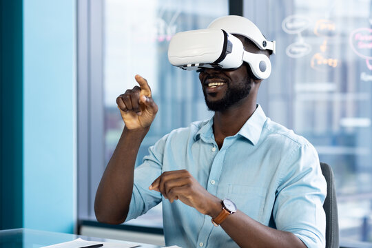 Using VR headset, man interacting with virtual environment in modern office