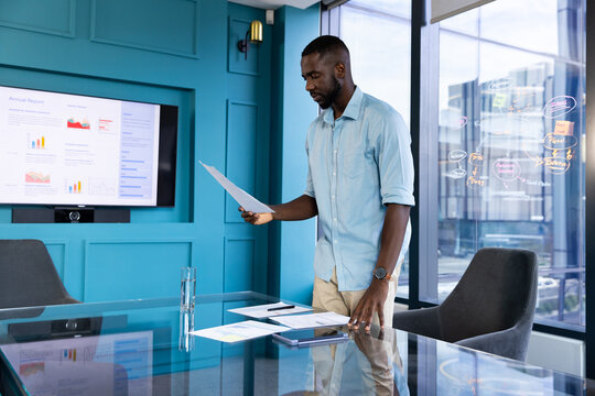 Presenting financial report, businessman standing in modern office with documents