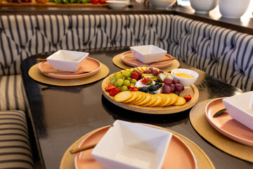 Serving fruit and crackers on table, preparing for meal with diverse friends at home, copy space