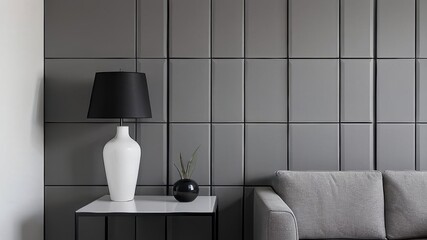 Grey wall panels and a black side table in minimalistic interior design composition.
