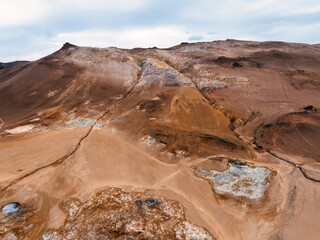 Aerial view of Hverir Geothermal Area in Iceland, capturing boiling mud pools, fumaroles, and the...