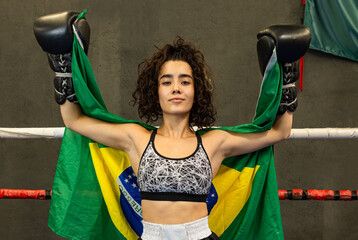 portrait of a South American athlete in a wrestling ring with the Brazilian flag on her back
