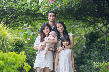 A Malaysian family taking a group photo in a stylish, nature-filled location in Selangor, Malaysia. The family includes a man, a woman, a girl, and a baby.
マレーシアのセランゴールにある、おしゃれで自然あふれる場所でマレーシア人の家族が集合写真