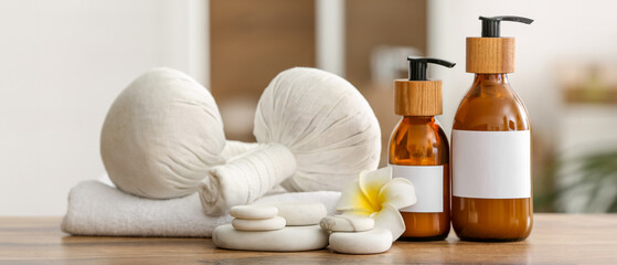 Set of spa accessories and bottles of cosmetic products on wooden table