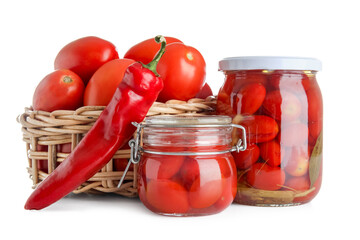 Jars of pickled tomatoes and chili pepper on white background