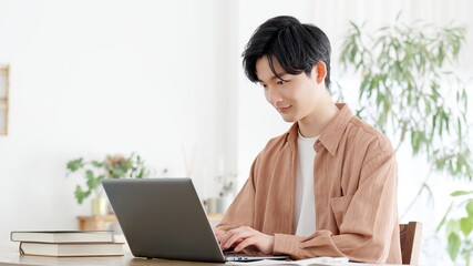 自宅でノートパソコンを使う男性