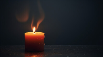 A burning candle against a background of darkness and fog