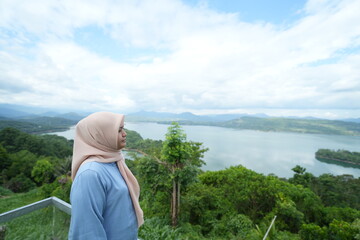 Muslim woman standing enjoying the beautiful panorama of Bollangi Hill in the morning