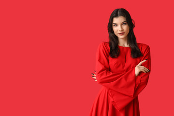 Fototapeta premium Beautiful young woman in stylish red dress on color background