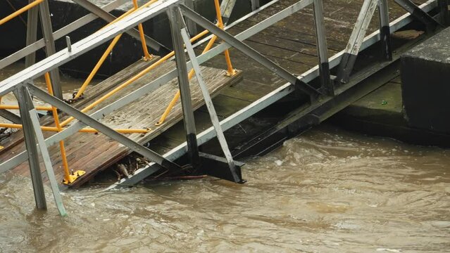 The bridge collapsed into the river and began to flood. The flood destroyed the bridge. Consequences of flood. Climate change, cataclysm, landslide