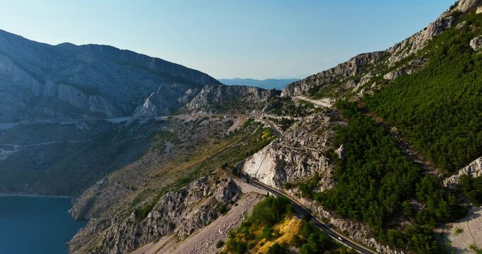 AERIAL: Mountainous winding road on the Makarska riviera, sunny day in Croatia