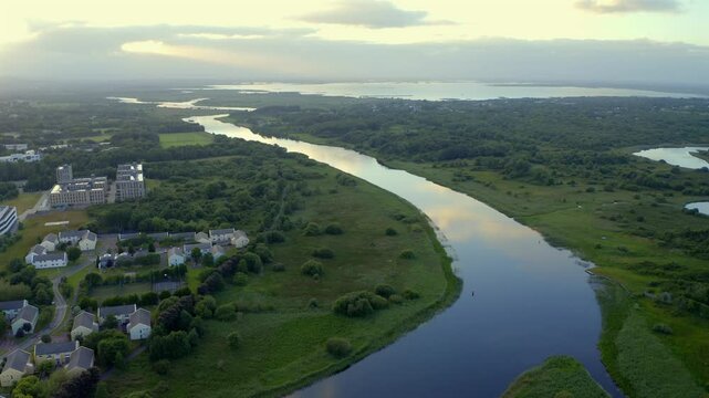Aerial view of River Corrib to lake as sunset golden sky reflects in calm water