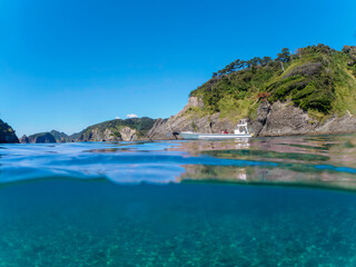 Obraz premium ヒリゾ浜渡船の漁船の美しい半水面撮影。日本国静岡県伊豆半島賀茂郡南伊豆町中木から渡し船で渡るヒリゾ浜にて。 2022年10月撮影。 