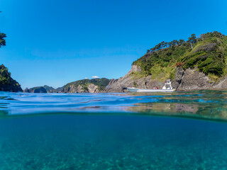 Fototapeta premium ヒリゾ浜渡船の漁船の美しい半水面撮影。日本国静岡県伊豆半島賀茂郡南伊豆町中木から渡し船で渡るヒリゾ浜にて。 2022年10月撮影。 
