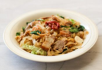 Kwetiau siram with vegetable and pork.