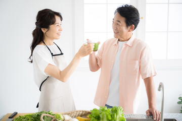 Image of a senior in the kitchen with a green juice who cares about her health Image of a healthy...