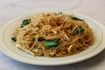 Bihun goreng with vegetable on plate.