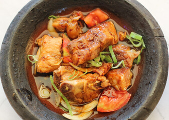 close up image of iga babi bakar on traditional plate. non halal food. indonesian chinese food. top of view.