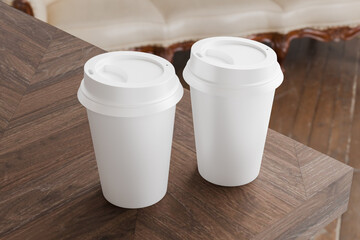 Two white take away coffee cup for mockup presentation branding design rendering minimalist blank close up with moody lighting calm and cozy engaging product display or disposable cup concept