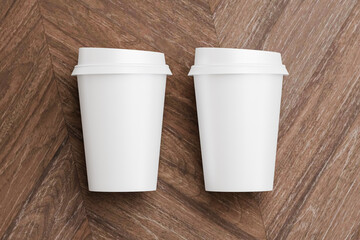 Two white take away coffee cup for mockup presentation branding design rendering minimalist blank close up with moody lighting calm and cozy engaging product display or disposable cup concept
