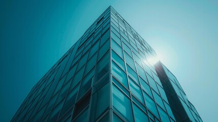Modern glass skyscraper against a clear blue sky, showcasing contemporary architecture and urban design. Concept of business, success, finance, and corporate world