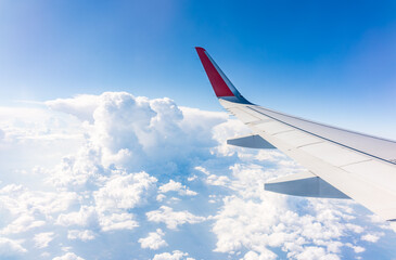 View from the airplane window at a beautiful cloudy sky and the airplane wing