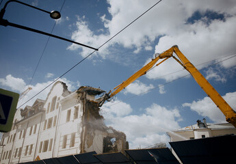 Excavator for demolition of buildings with a hydraulic crusher. The concept of demolition of buildings using excavators.