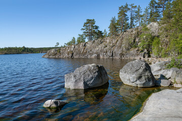 Two large granite blocks at the shore on a sunny June day. Koyonsaari Island, Ladoga Skerries. Karelia, Russia