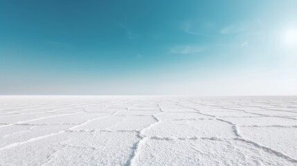 Wide view of a salt flat landscape under a clear blue sky, showcasing geometric patterns and vast emptiness in a tranquil natural setting.