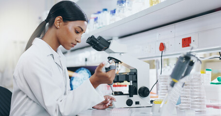Woman, science and working with microscope in laboratory, microbiology and research study of...