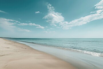 Fototapeta premium Serene beach with tranquil waves and a clear blue sky.