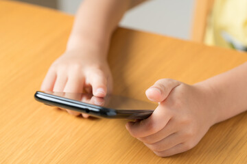 スマホをいじる子どもの手元
