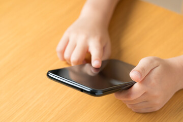 スマホをいじる子どもの手元