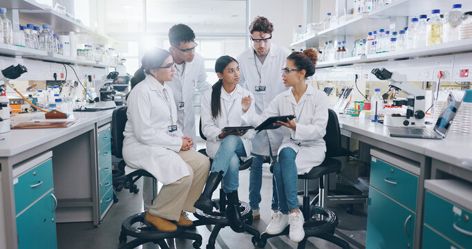 Tablet, science and group of people in laboratory for learning, cancer cure or medical development. Training, investigation and research with scientist team in clinical trial for medicine internship