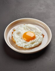 fried egg on black background