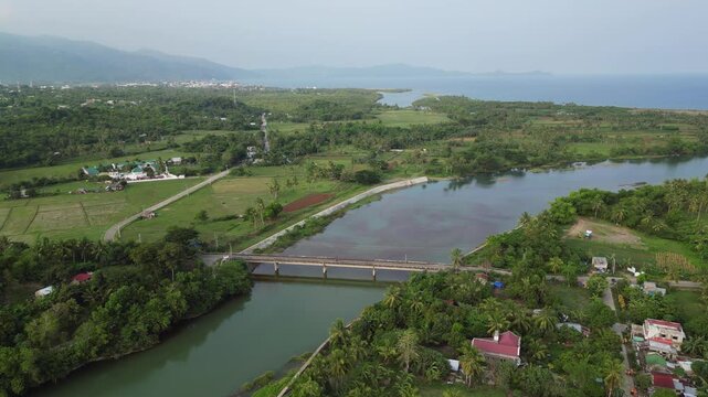 Bridge Across Pajo River On Coastline In Virac, Catanduanes, Philippines. aerial arc shot