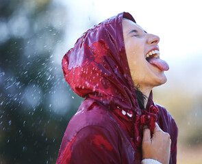 Rain, raincoat and woman with smile, carefree and fun in winter with waterproof, outdoor and...