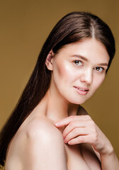 Youthful Brunette Woman with Flawless Skin. Close-up of a brunette woman with bare shoulders, radiating youthful and healthy skin. 