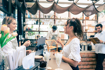 Caucasian attractive women receive coffee from waiter in coffee house. 