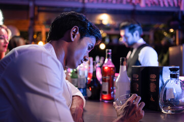 Asian depression man feeling heart broken and drinking beer in a bar. 
