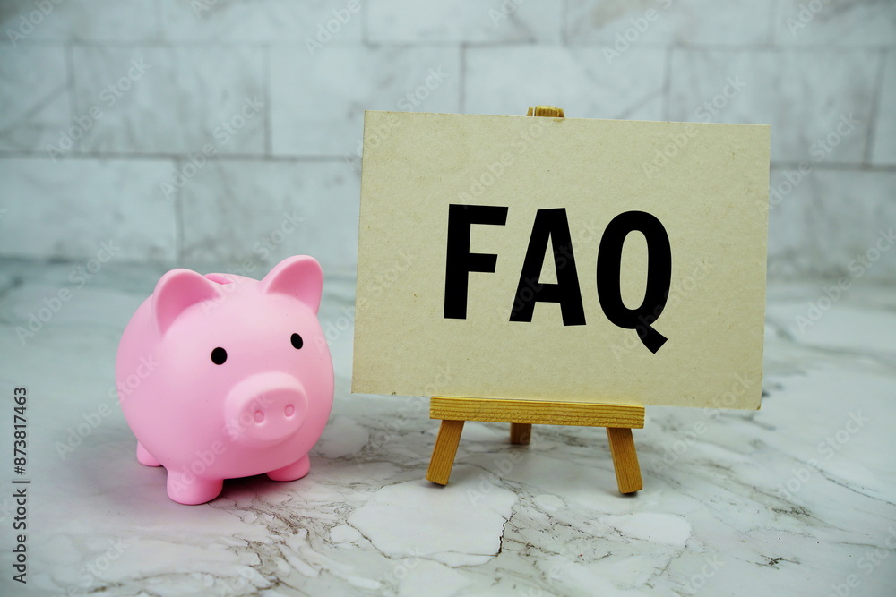 Poster faq text written on paper card with piggy saving on marble background