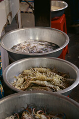 Exotic mantis shrimp or Stomatopoda and crabs in metal basin displayed at a local seafood market in Kampot Cambodia