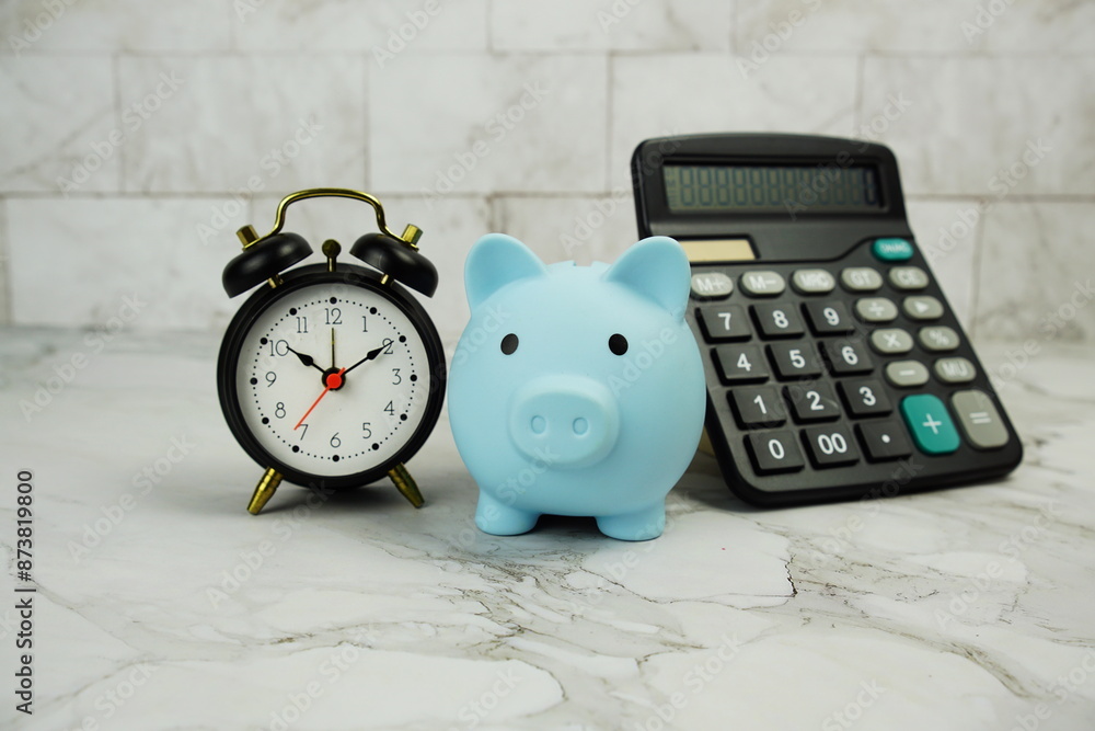 Poster piggy bank saving with alarm clock and calculator on marble background